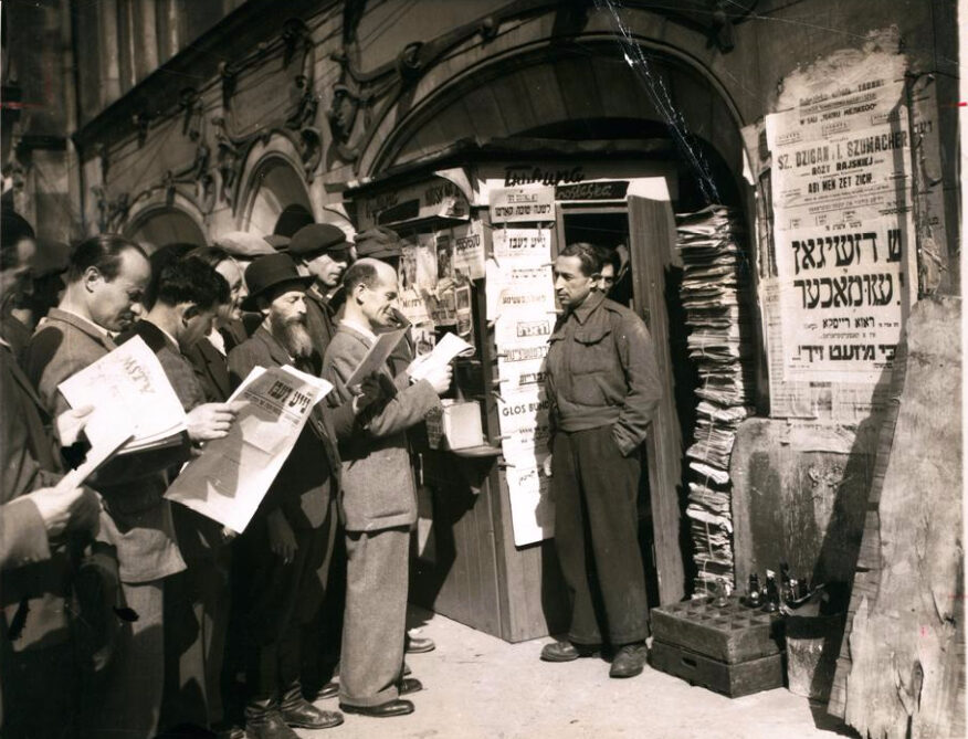 <p>People at a newsstand reading Jewish newspapers, Wrocław, 1947. (Associated Press; print courtesy YIVO)</p>