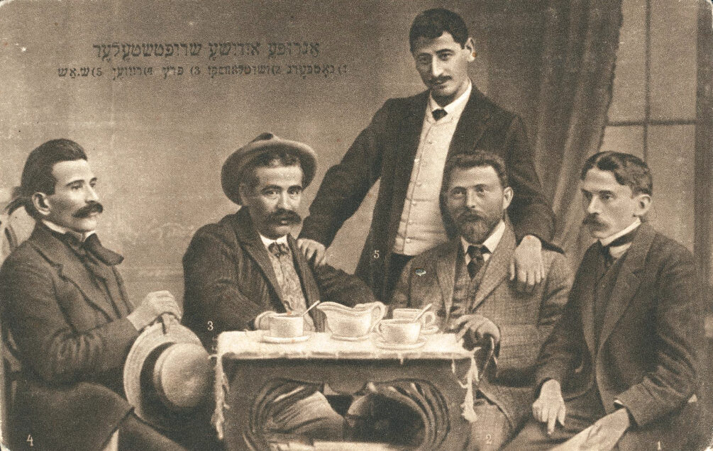 <p>Zhitlowsky pictured with other Yiddish writers at the Czernowitz  Conference in 1908. From left to right: Avrom Reyzen, Yitskhok Leybush Peretz, Sholem Asch, Khayim Zhitlovski, Hersh Dovid Nomberg. Postcard (Warsaw: Verlag Jehudia). (YIVO)</p>