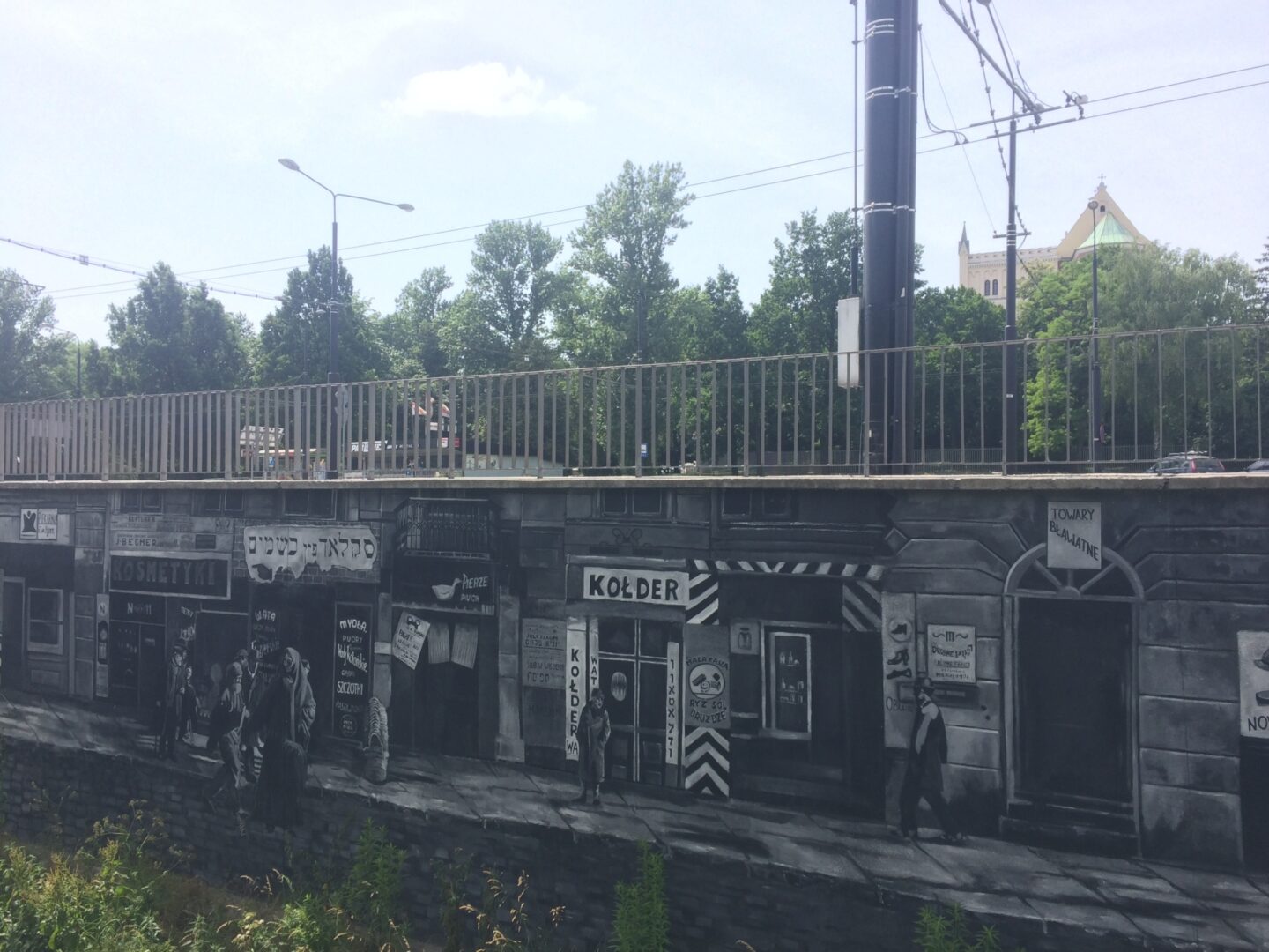 <p>Mural along the Czechówka river in Lublin, in the formerly Jewish neighborhood of Podzamcze. For more information, see <a href="https://teatrnn.pl/pamiec/en/the-mural-alongside-the-czechowka-river/">the Theater NN’s website</a>. Photo by the author.</p>