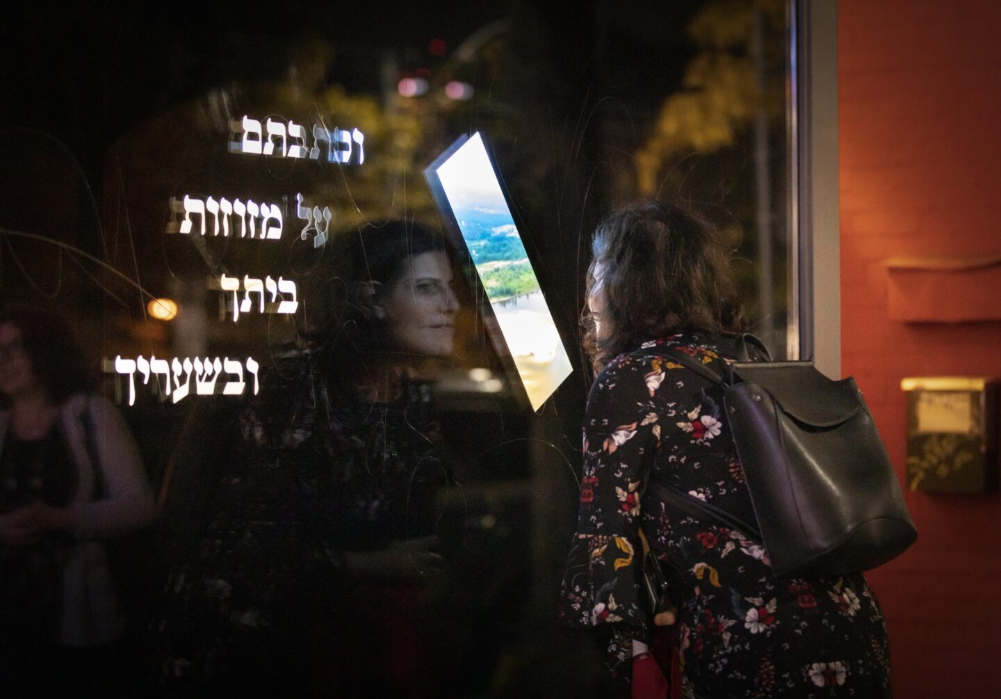 <p>A gallery-goer views FENTSTER’s <em>Mezuzah Okno</em> exhibition on its opening night (Justine Apple)</p>