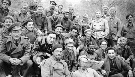 <p>Volunteers in the International Brigades in the Spanish Civil War, including one individual reading a copy of the Yiddish newspaper <em>Frayhayt</em>. Photograph from the Abraham Lincoln Brigade Archives, Tamiment Library, New York University.</p>
